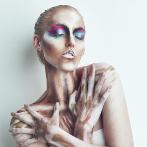 Embrace the strange. Studio shot of a young woman posing with paint on her face.